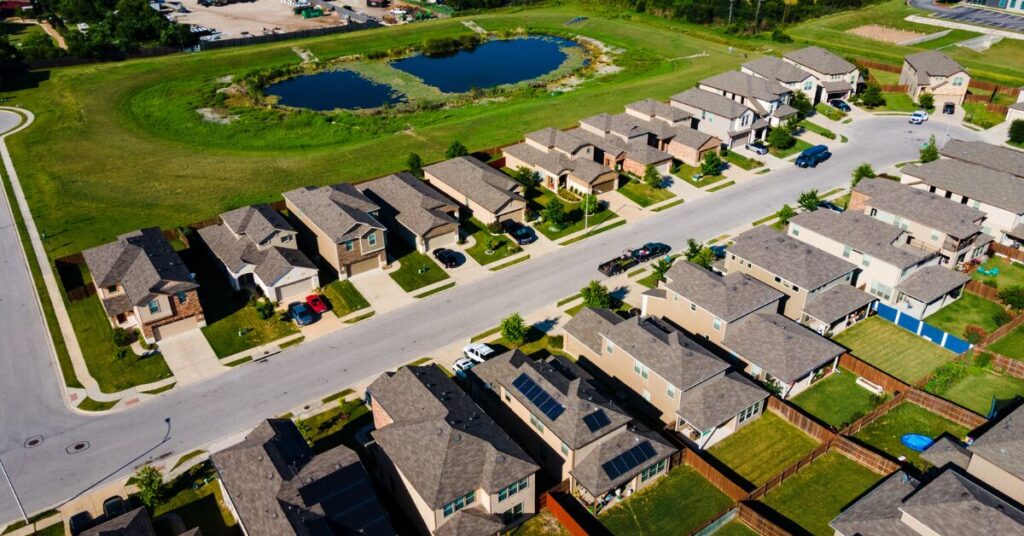 Aerial view of a suburban neighborhood with single-family rental homes, symbolizing real estate investing and material participation for tax purposes.