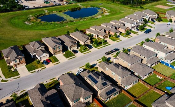 Aerial view of a suburban neighborhood with single-family rental homes, symbolizing real estate investing and material participation for tax purposes.