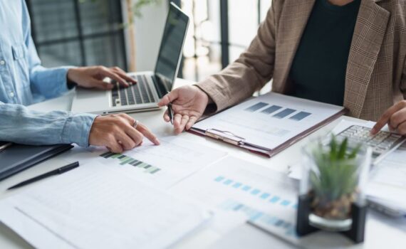 Real estate investors reviewing financial statements, charts, and spreadsheets during an accounting meeting.