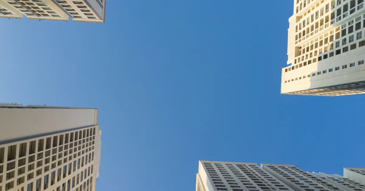 Upward view of modern commercial buildings against a clear blue sky, representing cost segregation strategies that remain available after year end